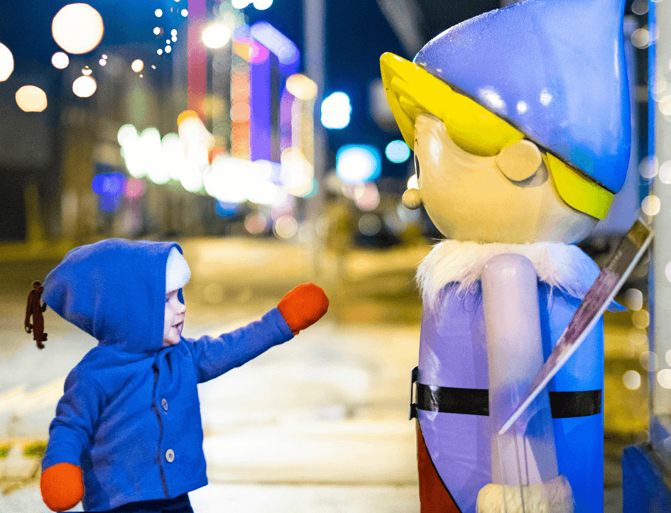 child pointing to an elf statue